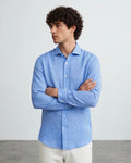 Hombre con camisa casual de lino azul claro de The Picks Club, manga larga y cuello clásico sobre fondo neutro