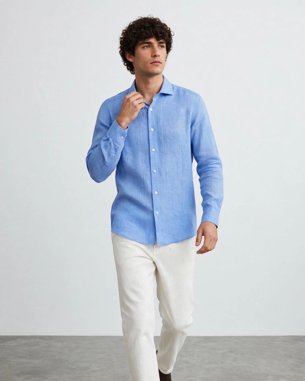 Camisa casual de lino color azul claro de The Picks Club lucida por un modelo con pantalones blancos