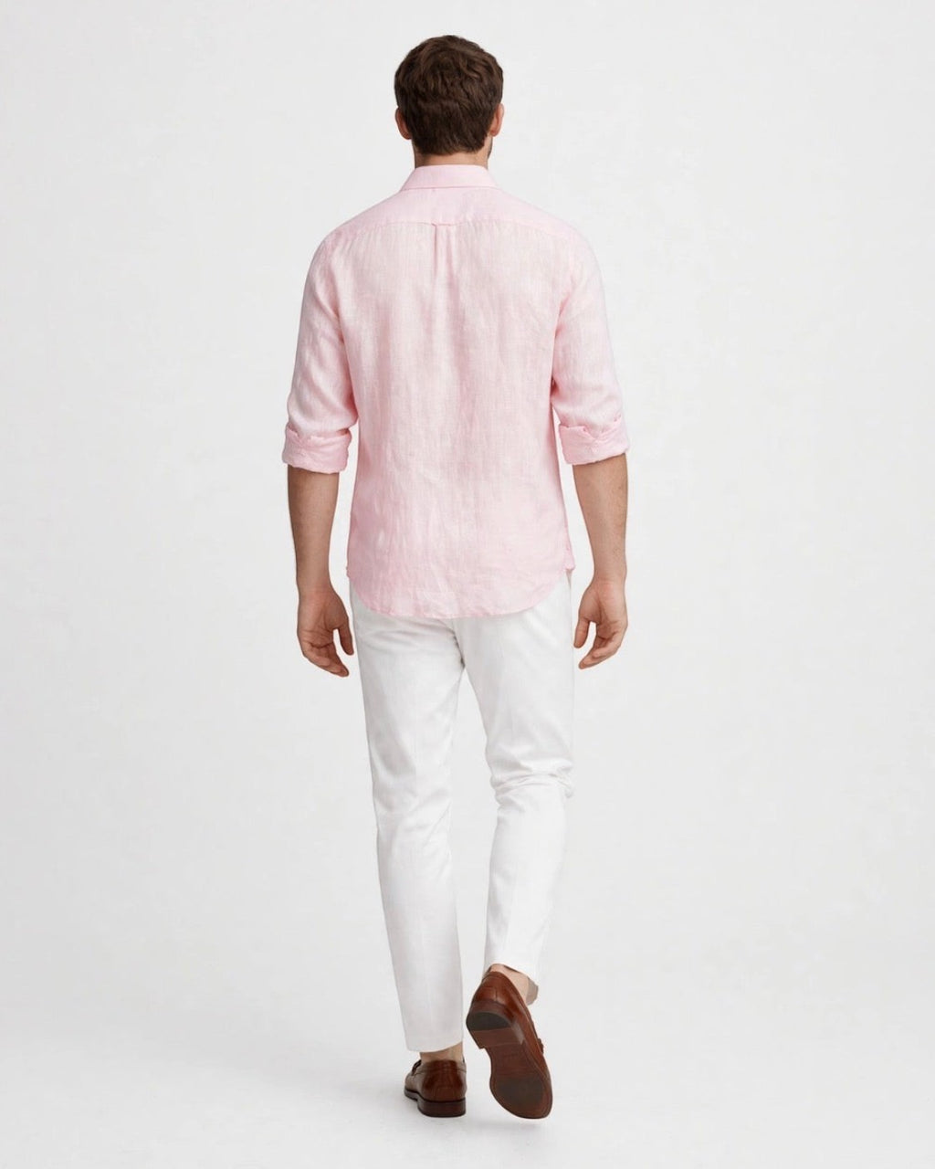 Vista trasera de hombre vistiendo camisa casual de lino color rosa de The Picks Club con pantalones blancos
