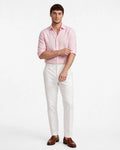 Camisa casual de lino color rosa blush de The Picks Club con mangas remangadas sobre pantalones blancos